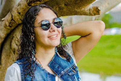 Portrait of young woman wearing sunglasses standing outdoors
