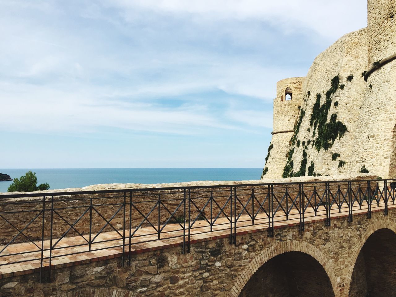 architecture, built structure, horizon over water, sky, history, sea, travel destinations, tourism, the past, building exterior, arch, tranquil scene, tranquility, stone wall, outdoors, day, famous place, stone material, cloud - sky, cloud, scenics, ancient, nature, medieval, no people, cliff
