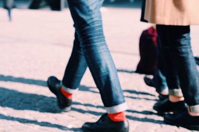 Low section of woman walking on road