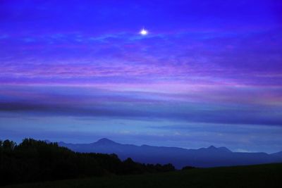 Scenic view of silhouette mountains against sky at night