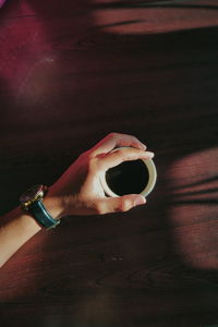 Midsection of person holding drink on table