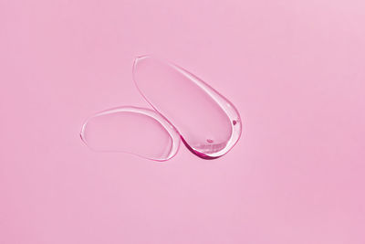 High angle view of water drop against pink background