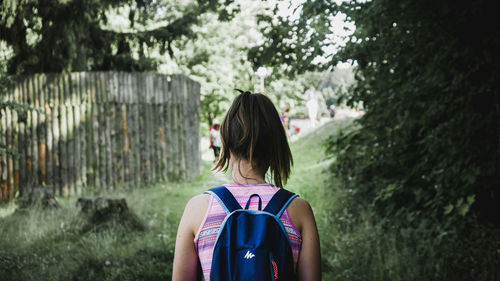 Rear view of woman standing against trees