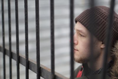 Thoughtful man by fence