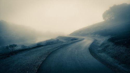 Empty road along snow covered landscape