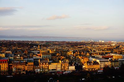 Aerial view of city against cloudy sky