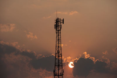 Low angle view of communications tower against sky during sunset