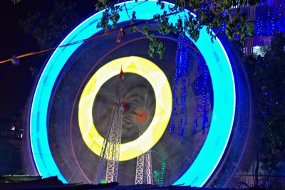 Low angle view of illuminated ferris wheel at night