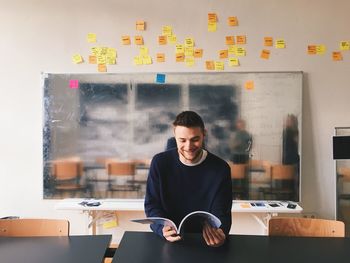 Portrait of man using mobile phone in office