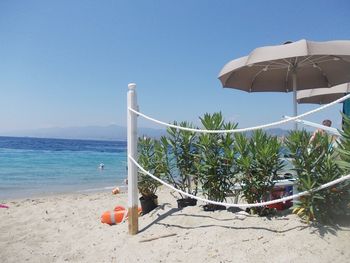 Built structure on beach against clear blue sky