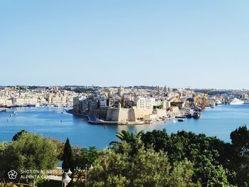 Panoramic view of city by river against clear sky