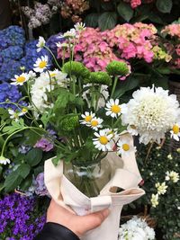 Midsection of person holding bouquet of flowering plant