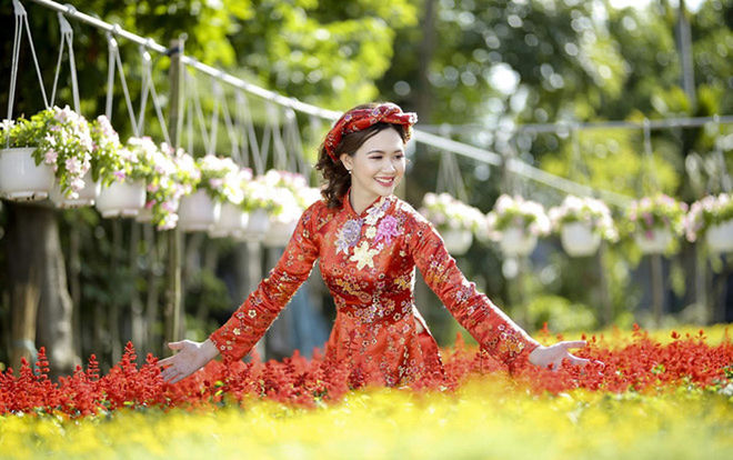 YOUNG WOMAN WITH RED FLOWER IN GARDEN