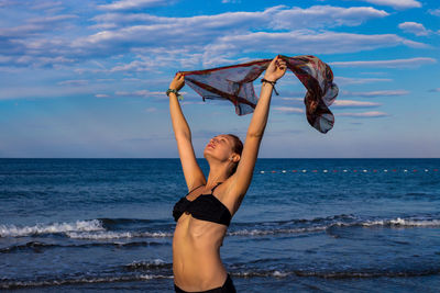 Full length of woman at beach against sky