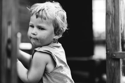 Portrait of baby girl playing in wooden house