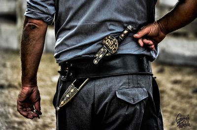 Midsection of man holding camera