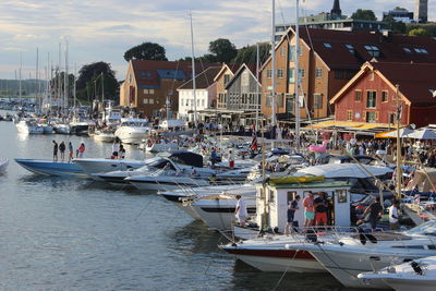 Boats moored in water against sky