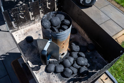 Lighting the home grill with coal, standing on a home garden on the paving stone.