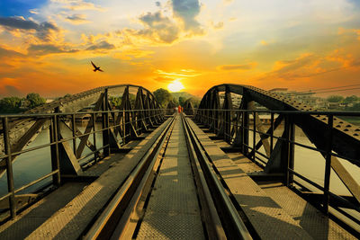 Bridge over sea against sky during sunset