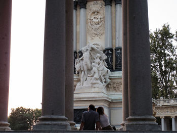 Rear view of man and woman relaxing at parque del buen retiro