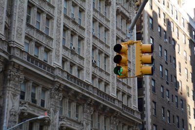 Low angle view of road signal traffic lights against buildings