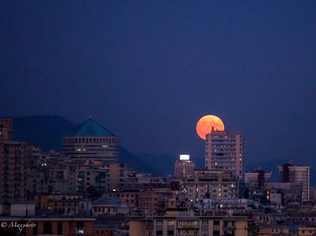 Buildings against blue sky at night