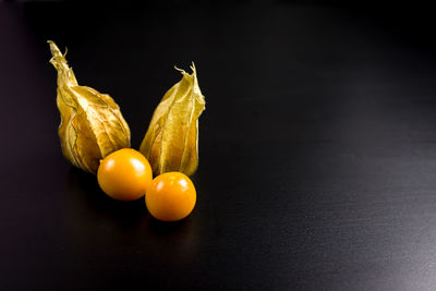 Close-up of fruits on table against black background