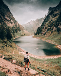 Man looking at lake against mountains