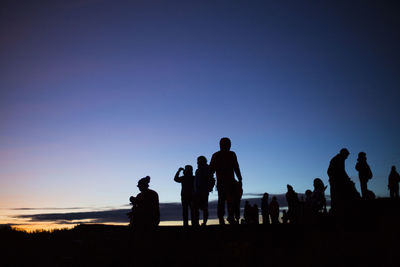 Silhouette people against clear sky during sunset
