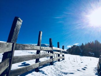 Snow covered landscape against blue sky