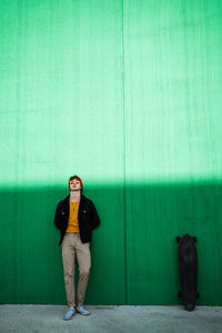 Portrait of smiling man standing against wall