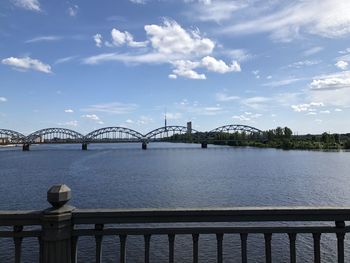 Bridge over river against cloudy sky