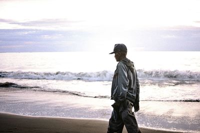 Man standing on beach against sky