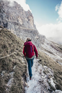 Rear view of man walking on rock