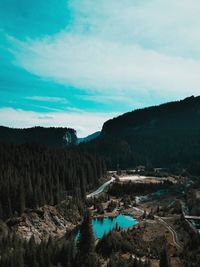 Scenic view of river by mountains against sky