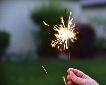 Close-up of hand holding sparkler at night