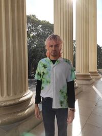 Portrait of young woman sitting on wall