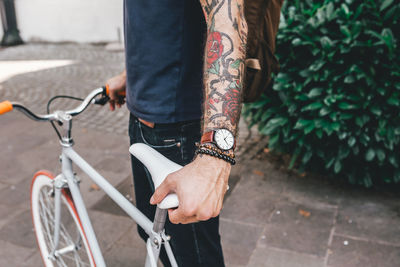 Low section of man with bicycle on street