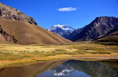 Scenic view of snowcapped mountains against blue sky