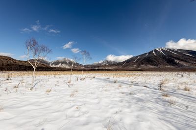 Scenic view of snowcapped mountains against blue sky