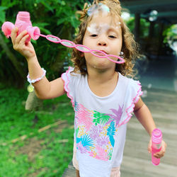 Full length of a girl holding bubbles