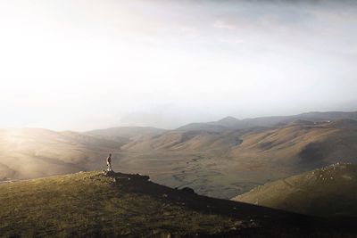 Man standing on mountain against sky