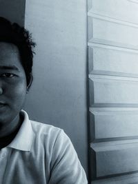 Portrait of young man looking away against wall
