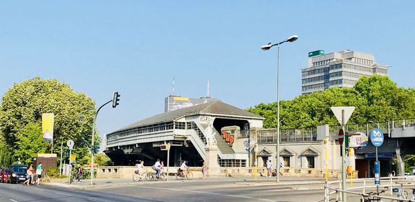 Street by buildings against clear blue sky