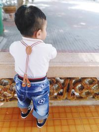 Rear view of boy looking at camera