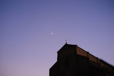 Low angle view of buildings against clear sky at night