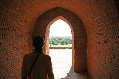 Rear view of man standing against wall