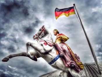 Low angle view of flag statue against sky