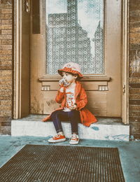 Close-up of girl sitting on doorstep