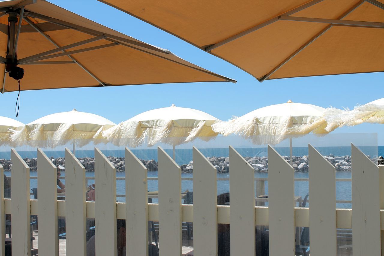 LOW ANGLE VIEW OF UMBRELLAS AGAINST SKY